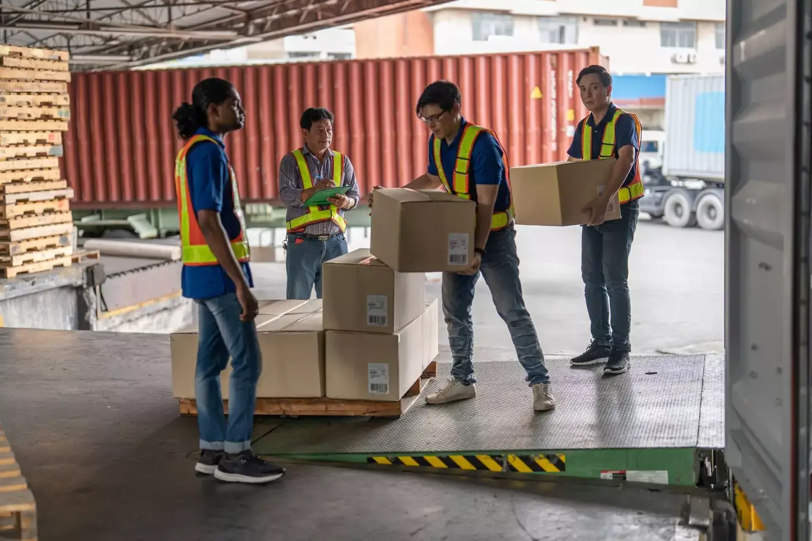 Muncitori asiatici manipulând marfă și pregătind pachetele pentru livrare într-un depozit, ilustrare a serviciilor de recrutare din Asia pentru logistică.