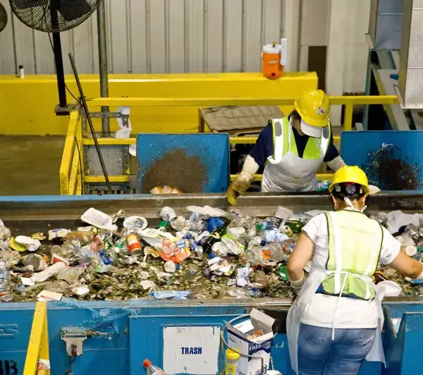 Lucrător asiatic sortând deșeuri reciclabile pe linia de reciclare – recrutare personal calificat din Asia pentru industria reciclării în România.